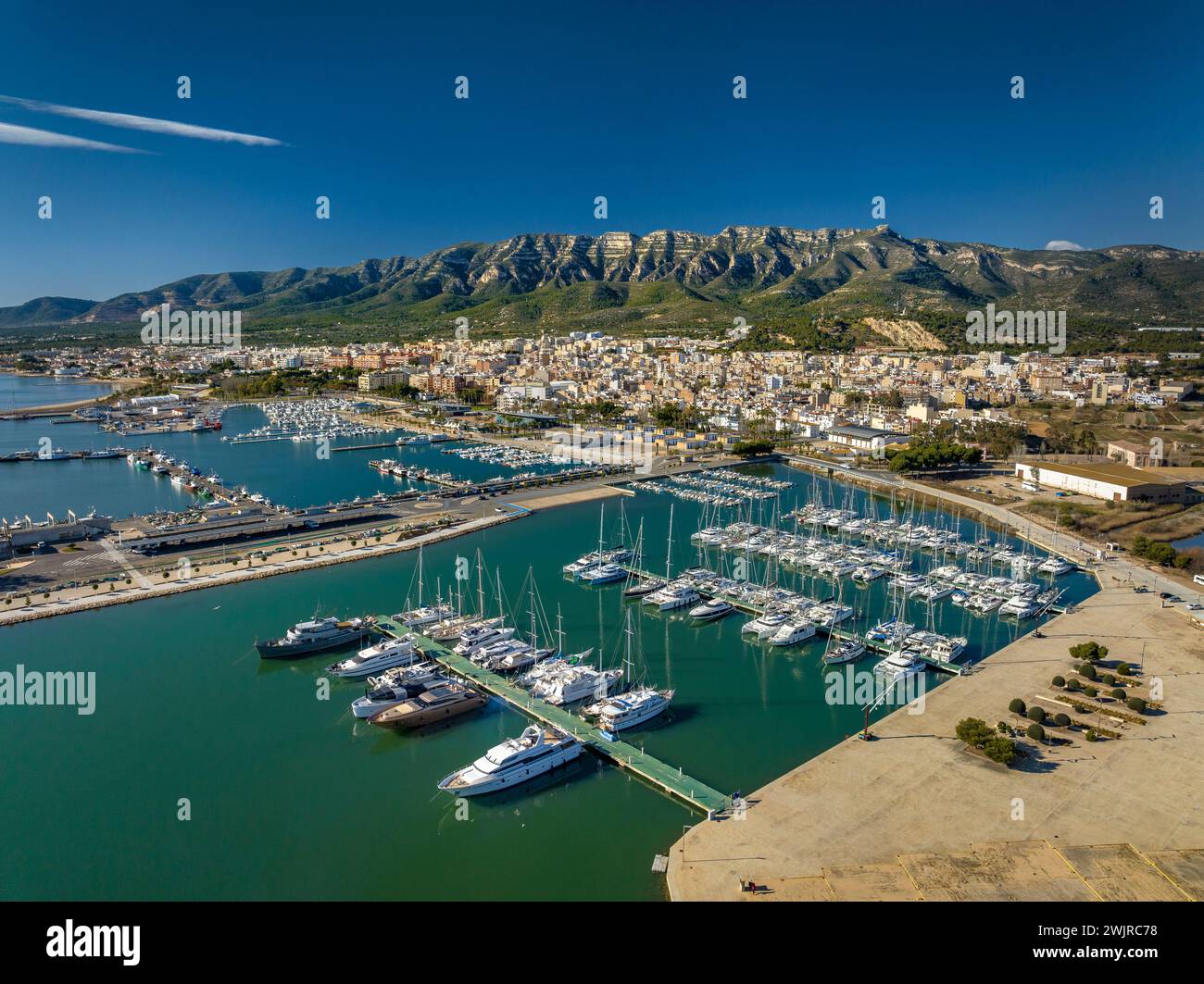 Vue aérienne de la ville de la Ràpita et de son port au premier plan. En arrière-plan, la chaîne de montagnes Montsià (Tarragone, Catalogne, Espagne) Banque D'Images