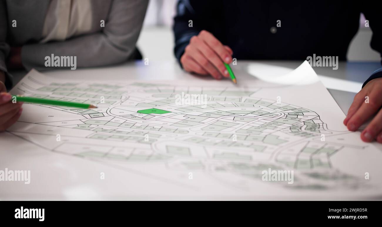 Close-up of Human Hand Holding crayon papier sur la carte du cadastre Banque D'Images