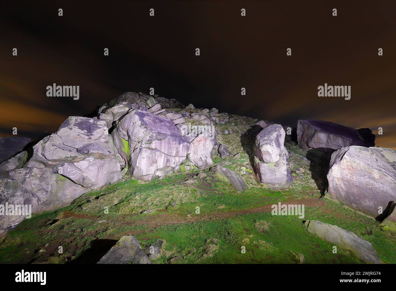 Almscliffe Crag illuminé par une torche la nuit. Banque D'Images
