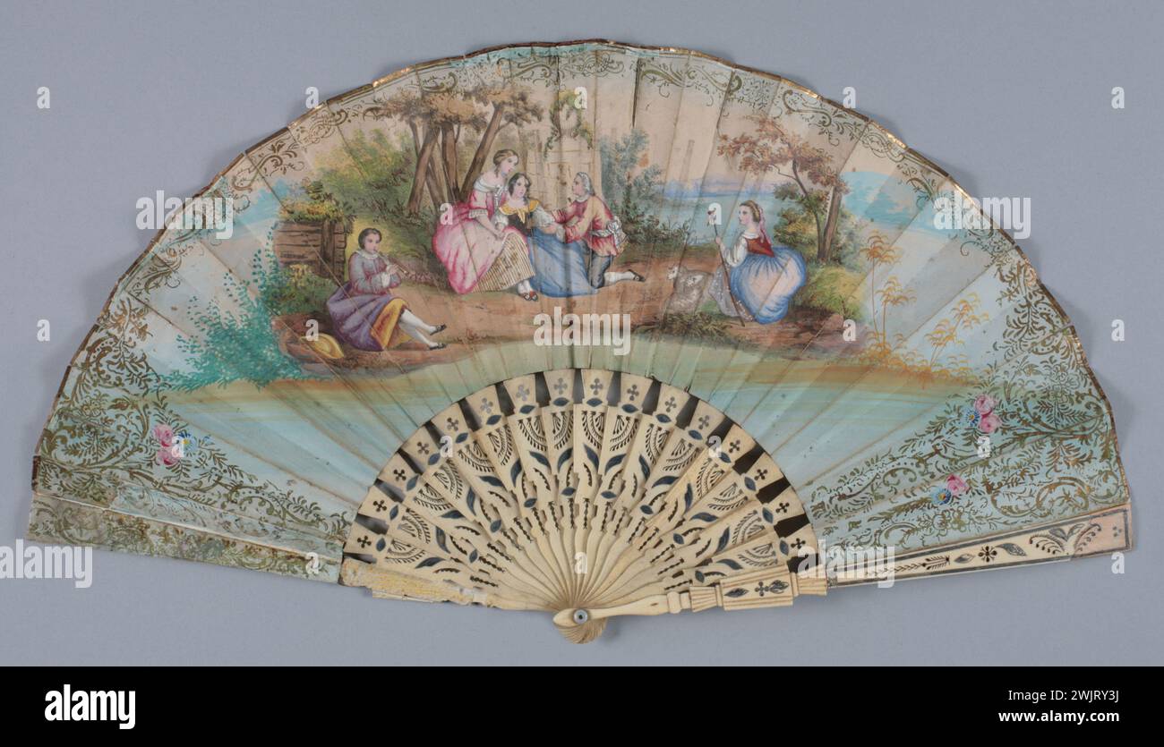 Gamme pliée, décor face scène pastorale : 2 femmes et un homme au pied d'un arbre regardent une bergère et ses moutons écoutant un jeune homme qui joue de la flûte, bordure de feuilles et de fleurs. Banque D'Images