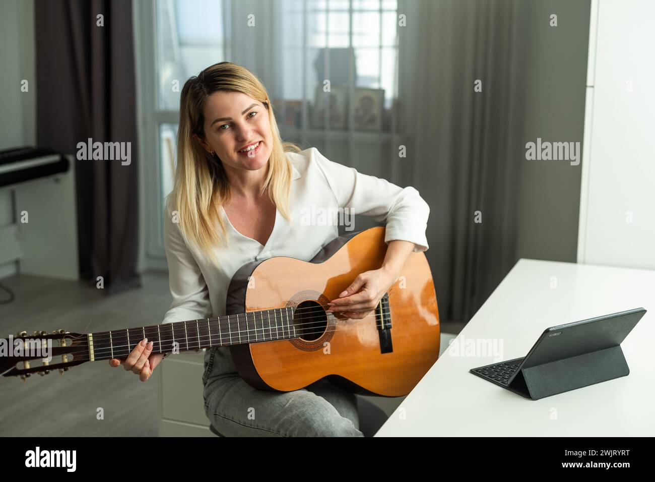 femme tenant une guitare avec ses mains Banque D'Images