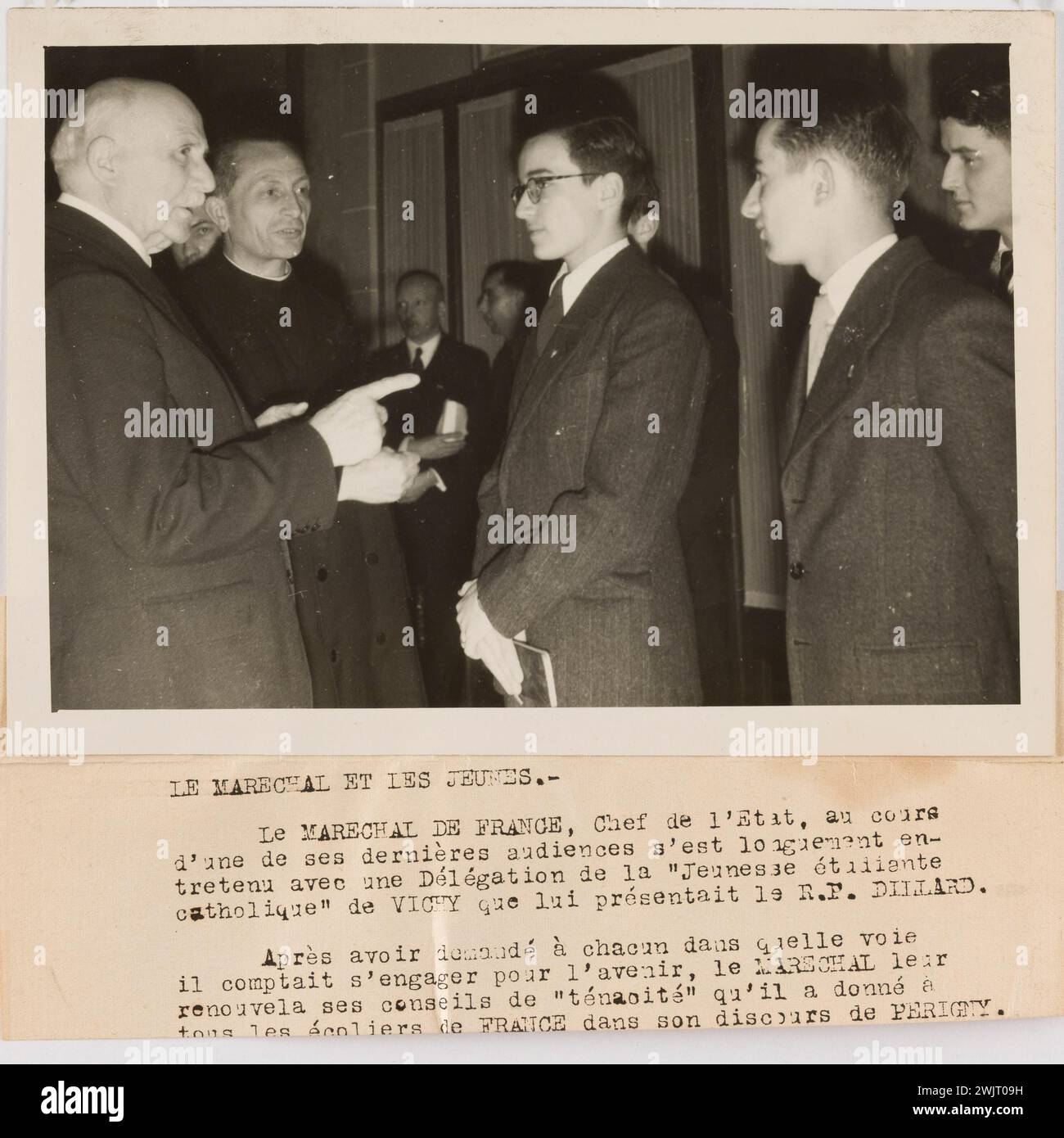 Rota III 'Photographie de propagande : le maréchal Pétain discute avec une délégation de l'étudiant catholique de Vichy'. Le Maréchal et les jeunes. / Le Maréchal de France, chef de l'Etat, pendant, / une de ses dernières audiences a longtemps été en / dessiné avec une délégation de l'étudiant / de la jeunesse catholique de Vichy qui lui a été présentée par le R.P. Dillard ; / après avoir demandé à chacun de quelle manière / il entendait s'engager pour l'avenir, le maréchal / a renouvelé leur conseil comme "ténacité" qu'il a donné à / tous les écoliers de France dans son discours à Périgny. Tirage au bromure de gélatino-argent. Dactylographié Banque D'Images