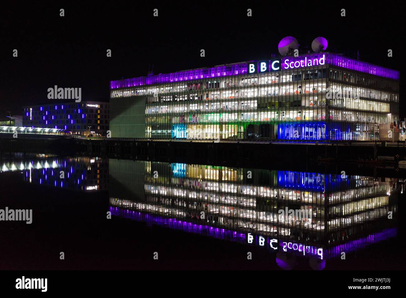 Glasgow Ecosse : 11 février 2024 : River Clyde la nuit avec le bâtiment BBC Scotland illuminé par le refelction d'eau. BBC Pacific Quay Banque D'Images