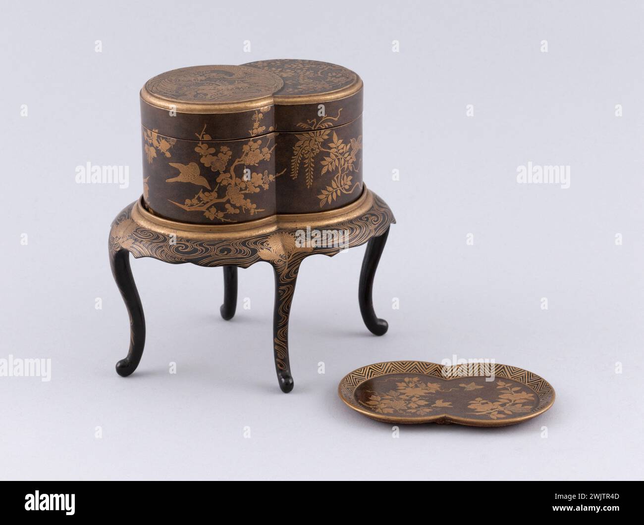 Anonyme. Double boîte sur une table de 4 pieds ; laque dorée décorée avec l'oiseau fö, fleurs et feuillage ; intérieur contenant plateau en laque dorée. Aperçu avec plateau. Laque. Musée des Beaux-Arts de la ville de Paris, petit Palais. Décor oiseau FO, double boîte, feuillage, fleur, objet de laque, or, plateau, vue de table, table Banque D'Images