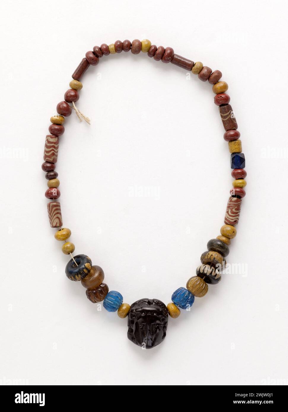 Anonyme. Collier de perles de verre avec pendentif (assemblage moderne). Pâte de verre polychrome, verre, ivoire noir. viie siècle -?. Paris, musée Carnavalet. Bijou, collier, ivoire noir, pâte polychrome, pendentif, perle de verre, verre, vestige archéologique Banque D'Images