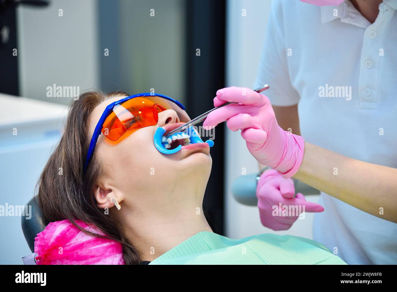 Femme dentiste prépare le patient à la procédure de blanchiment des dents. Concept de blanchiment dentaire et dentaire. Banque D'Images Femme dentiste prépare le patient à la procédure de blanchiment des dents. Concept de blanchiment dentaire et dentaire. Banque D'Images