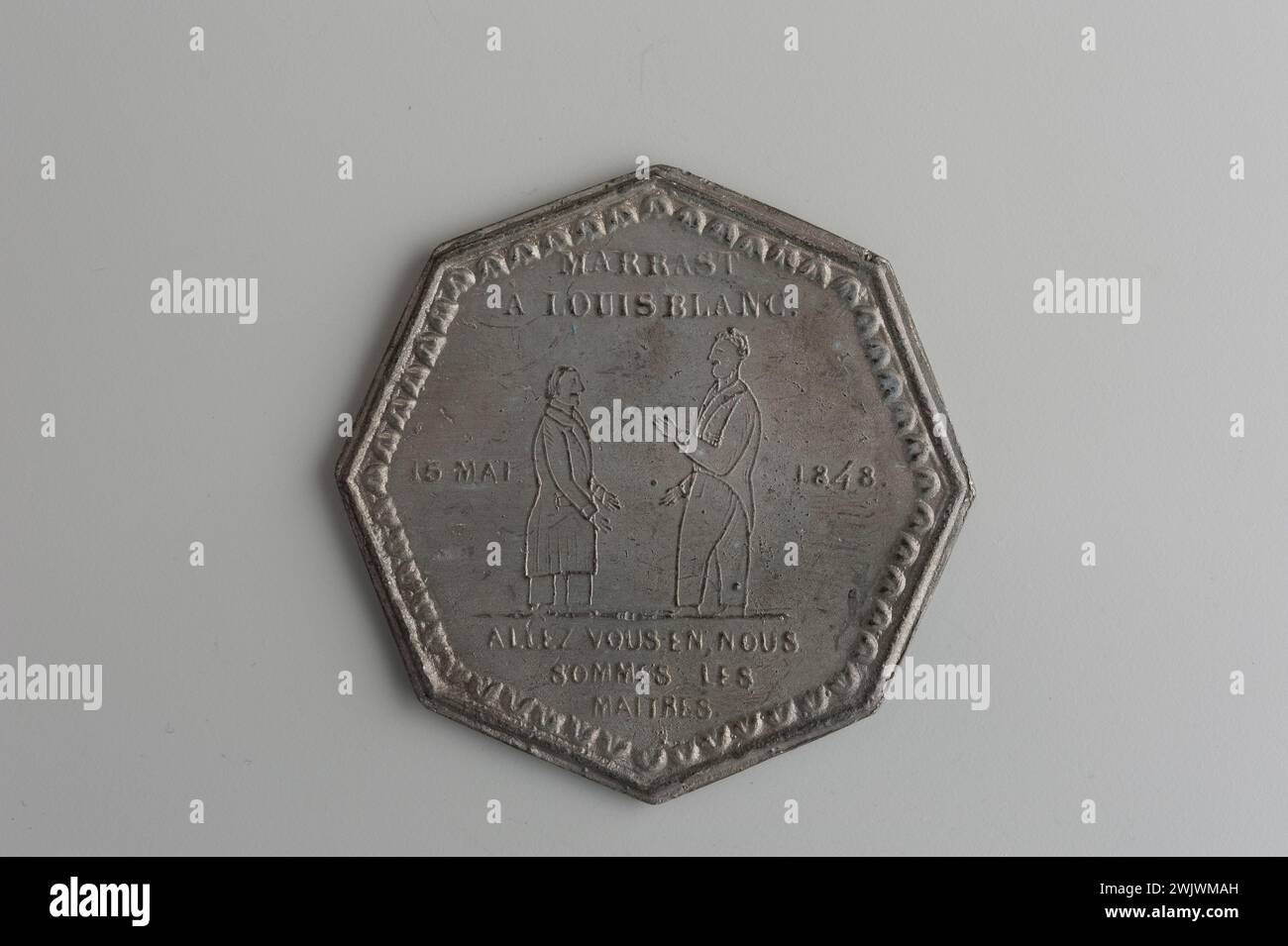 Musée Carnavalet, collection de médailles droit dans une frise de fleurs de lotus stylisées, deux personnages au pied face à eux, celui de gauche (Barbès) est plus grand et lève le bras; inverser dans une frise de fleurs de lotus stylisées, deux personnages dans le pied face à eux-mêmes, celui de droite (Marrast) est plus grand et lève le bras. Banque D'Images