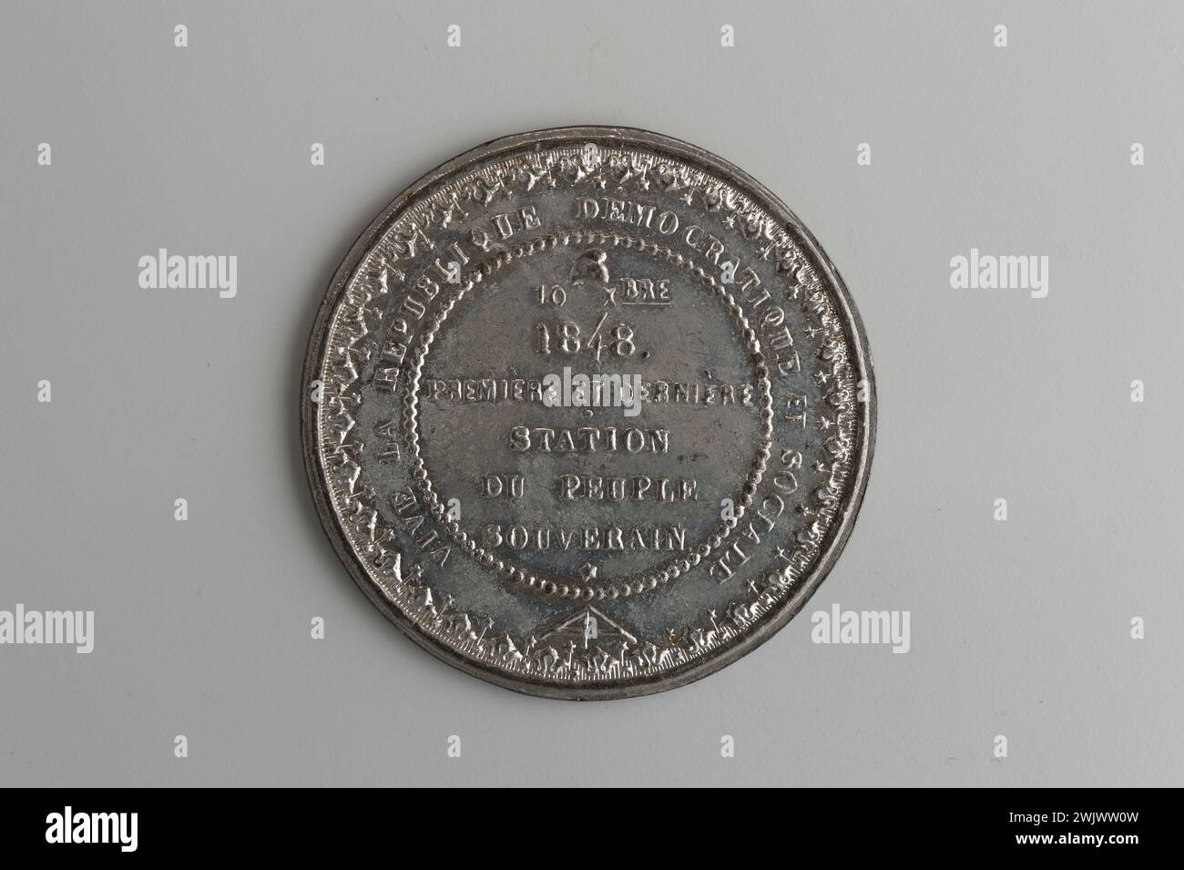 Musée Carnavalet, collection de médailles inscription droite sur six lignes entre un chapeau phrygien et en dessous une étoile au-dessus, ceci dans un cercle de perles ; inscription circulaire entourée d'une deuxième frise composée de fleurs de lotus stylisées alternant avec des étoiles ; grand fléau et une ligne d'inscription. Banque D'Images