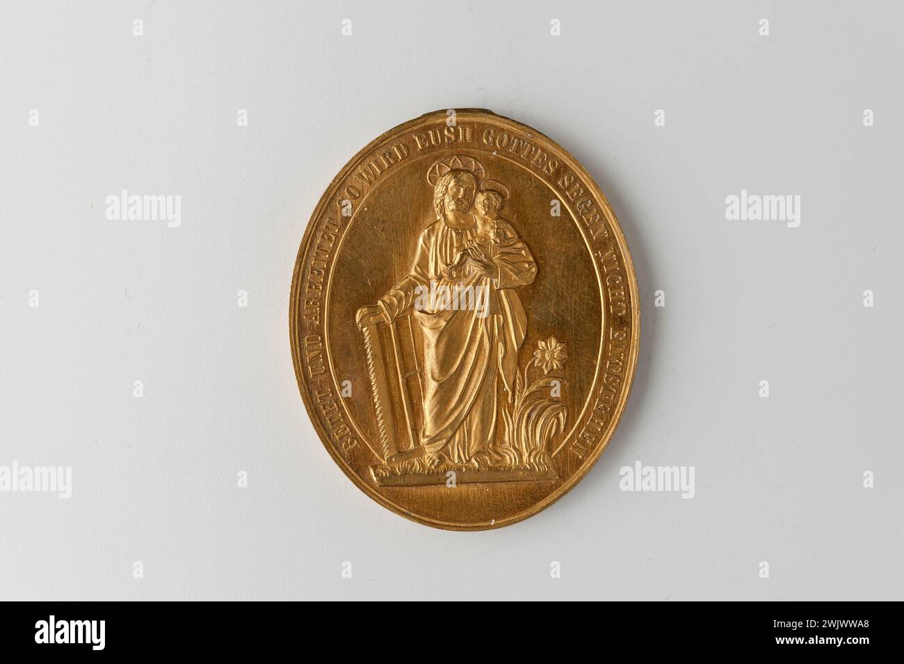 Musée Carnavalet, collection de médailles droite saint joseph debout de face s'appuyant de la main droite sur une scie charpentier et tenant dans le bras gauche l'enfant Jésus ; inscription inversée sur quatre lignes. Banque D'Images