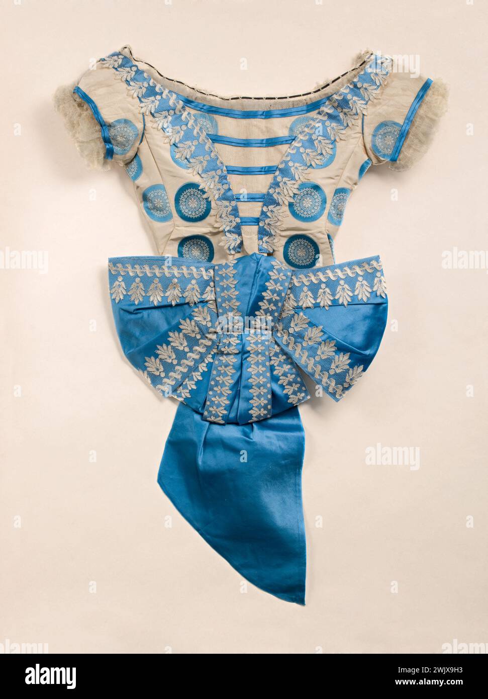 Corsage de balle et ceinture avec grand noeud. Soie façonnée, défaut ivoire avec noulles bleues, satin bleu et tulle de soie, blond mécanique. 1866-1867. Galliera, musée de la mode de la ville de Paris. 39306-5 Bleu, Mecanic blonde, ceinture, cercle bleu, corsage de balle, faille de fuseau, femelle, gros nœud, ivoire, nœud, nouelle, satin, second empire, soie faconnee, tulle de soie Banque D'Images