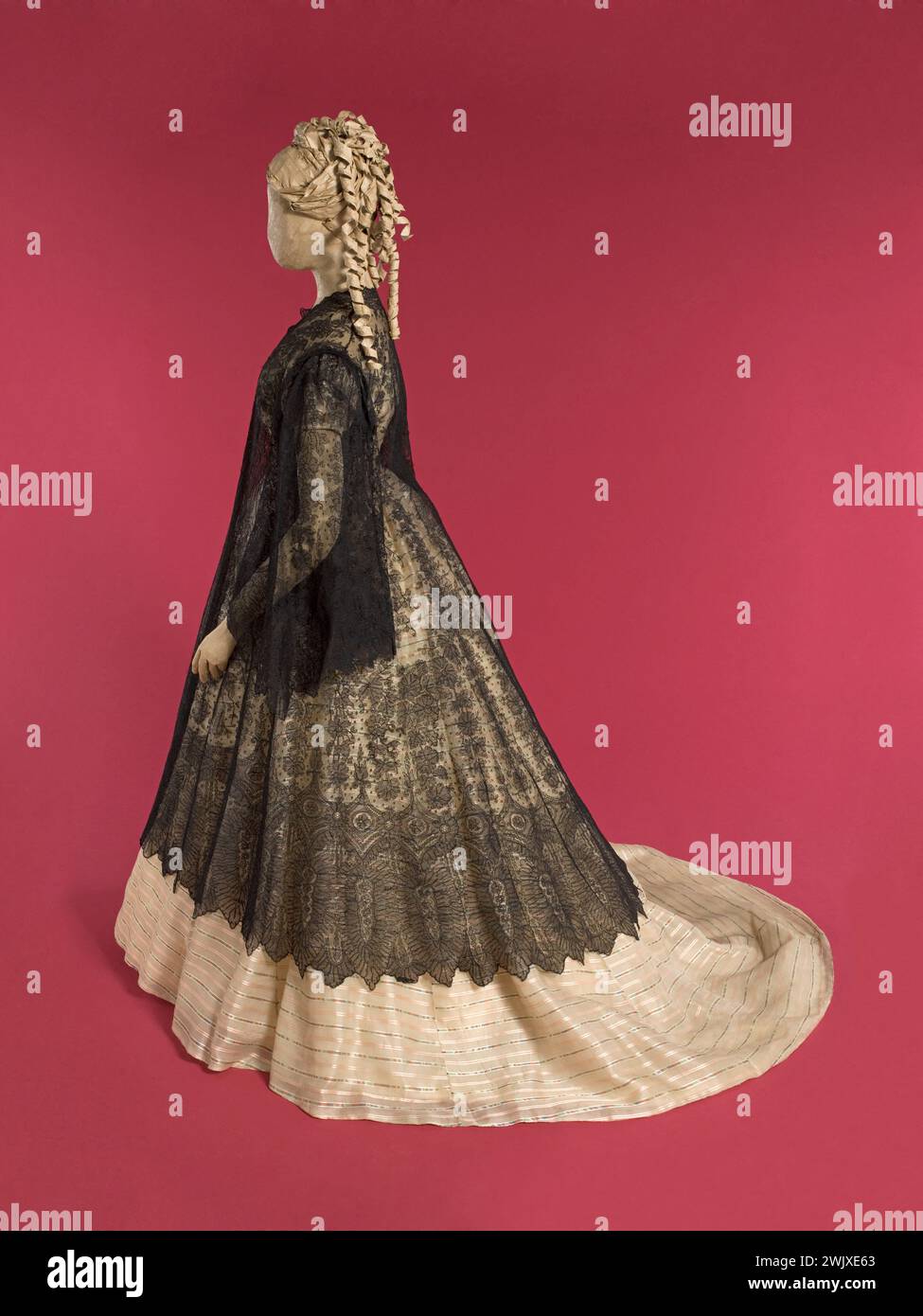 Manteau et robe de bal. Pelage : Talma, dentelle crème fouettée mécanique noire. Robe : gaze de soie beige irritée avec des rayures satinées roses, rouges, bleues et marron, boutons recouverts de maisons fleuries. 1864-1866. Galliera, musée de la mode de la ville de Paris. Bandes horizontales. Dentelle mécanique, femelle, gaze de soie beige, mannequin, manteau, usine de passager, bande satinee, robe de bal, deuxième empire, talma, crinoline Banque D'Images