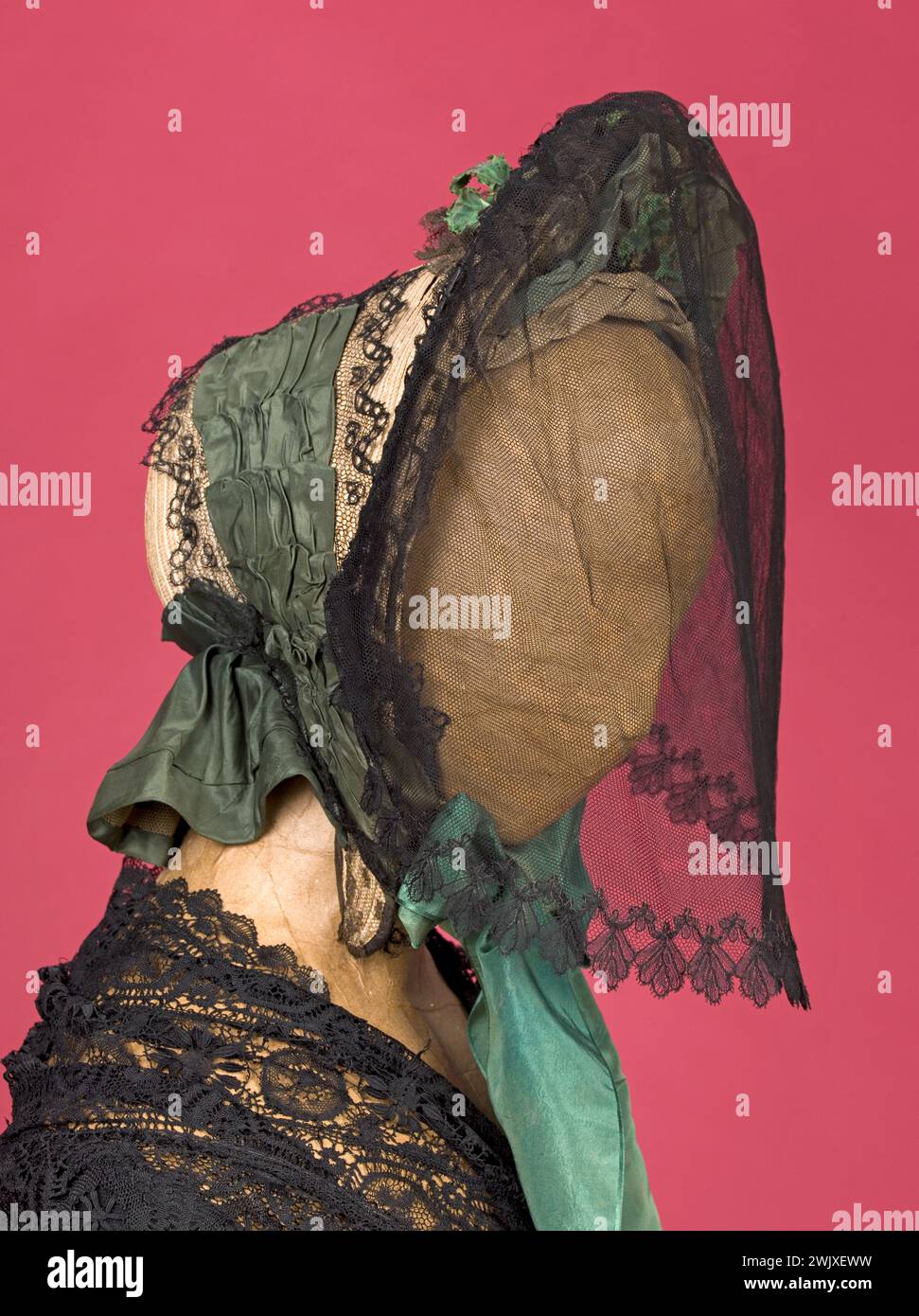 Voile de coppe et dentelle. Capote : paille blonde, crème fouettée noire, rubans de taffetas vert. Voilette : montée en laiton, double tulle, bord de dentelle Chantilly, broches. Vers 1860. Galliera, musée de la mode de la ville de Paris. Guirlande de feuilles. Capote, crème fouettée noire, paille blonde, ruban, second empire, taffetas vert, tulle, voile de dentelle, chapeau Banque D'Images