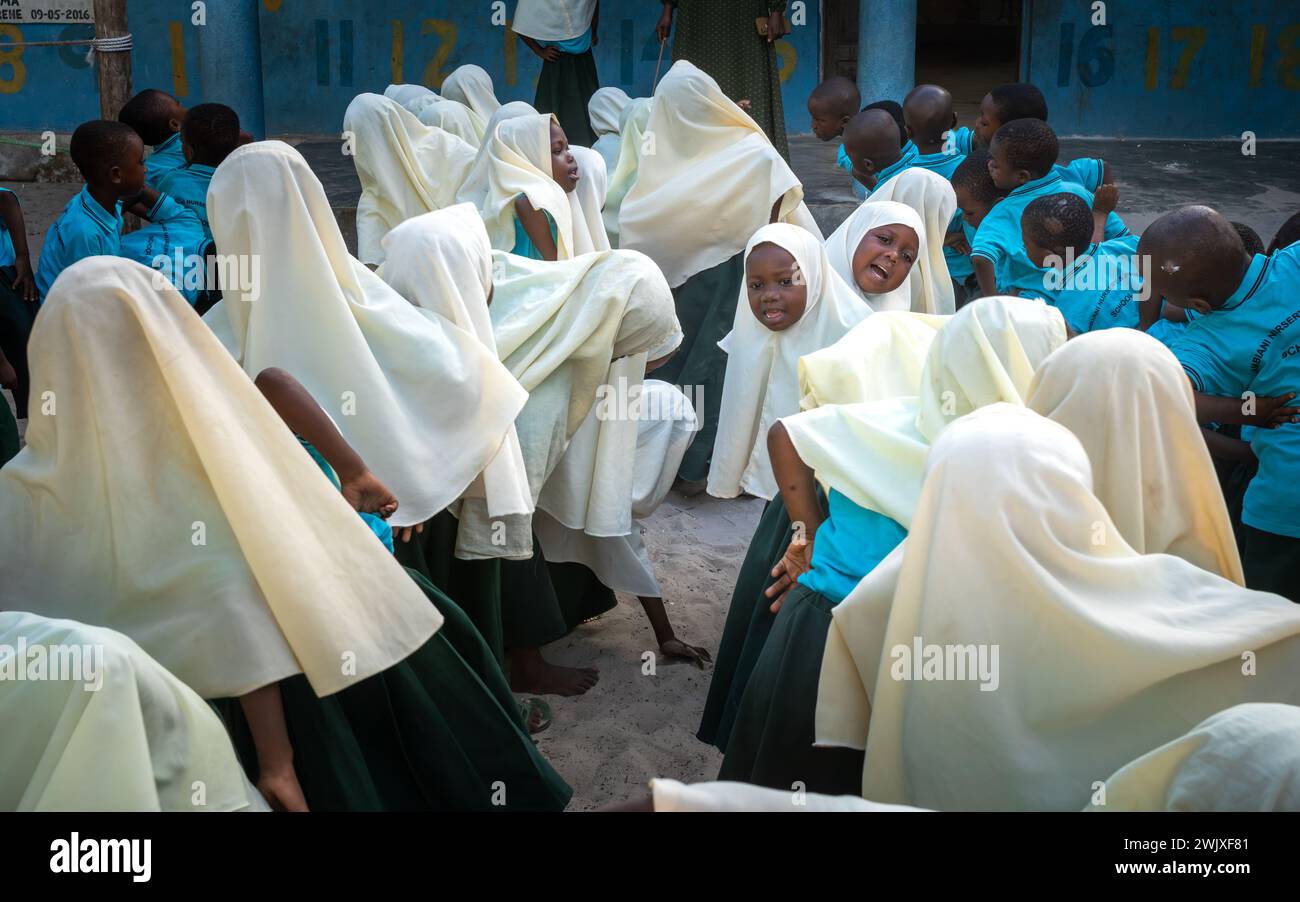 Jeunes garçons et filles musulmans à l'Assemblée du matin à l'école primaire de Jambiani à Jambiani, Zanzibar, Tanzanie. Banque D'Images
