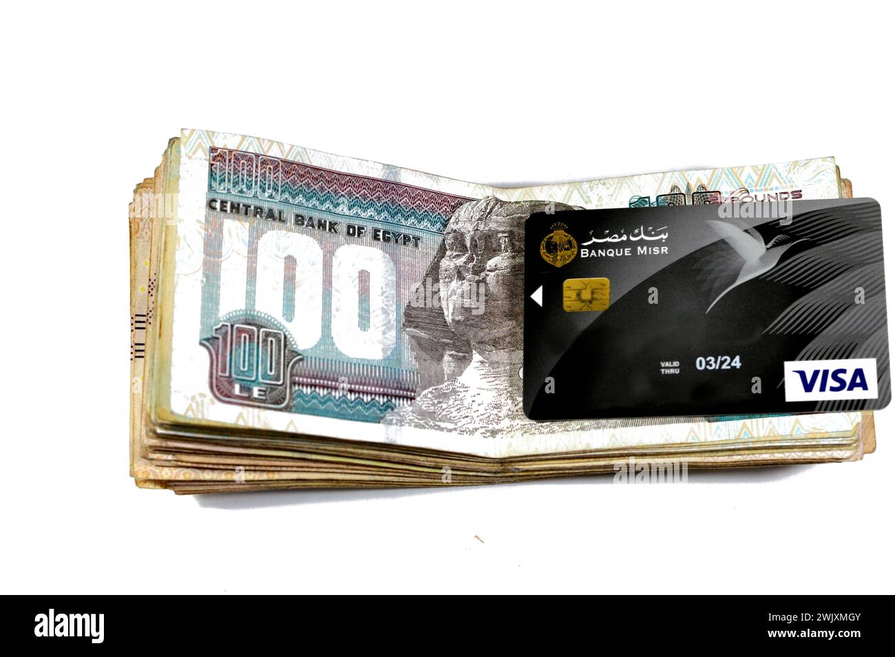 Le Caire, Egypte, 12 février 2024 : pile de billets de banque égyptiens de 100 cents livres et Banque Misr ou Egypte Banque carte VISA DE paiement électronique pour Banque D'Images
