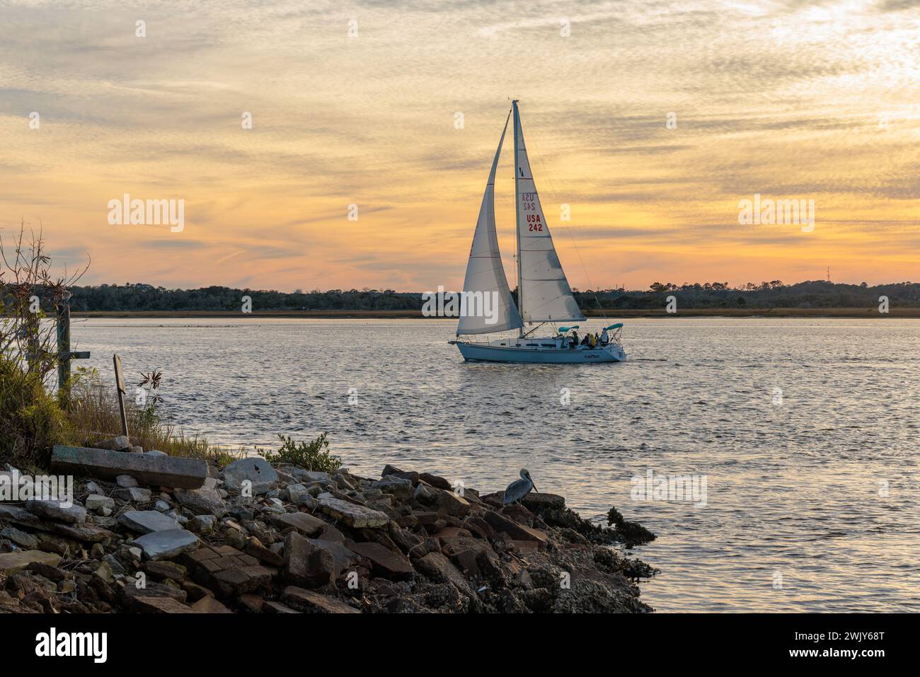 Voilier naviguant sur la rivière Tolomato près de Vilano Beach, Floride au coucher du soleil Banque D'Images Voilier naviguant sur la rivière Tolomato près de Vilano Beach, Floride au coucher du soleil Banque D'Images