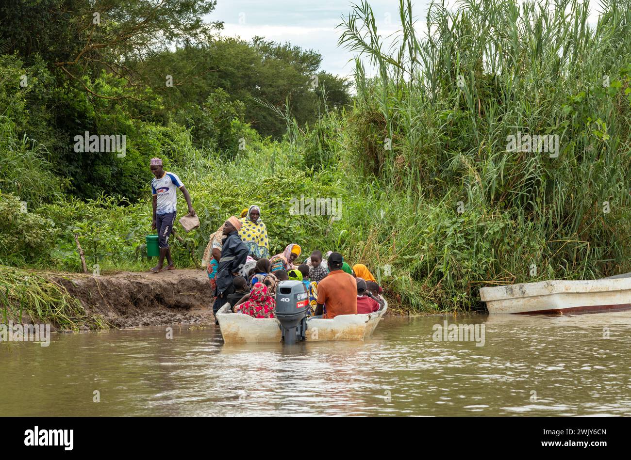 Les villageois montent à bord d'un petit ferry traversant la rivière Rufiji à Mwaseni, dans le parc national Nyerere (réserve de gibier de Selous) en Tanzanie. Banque D'Images