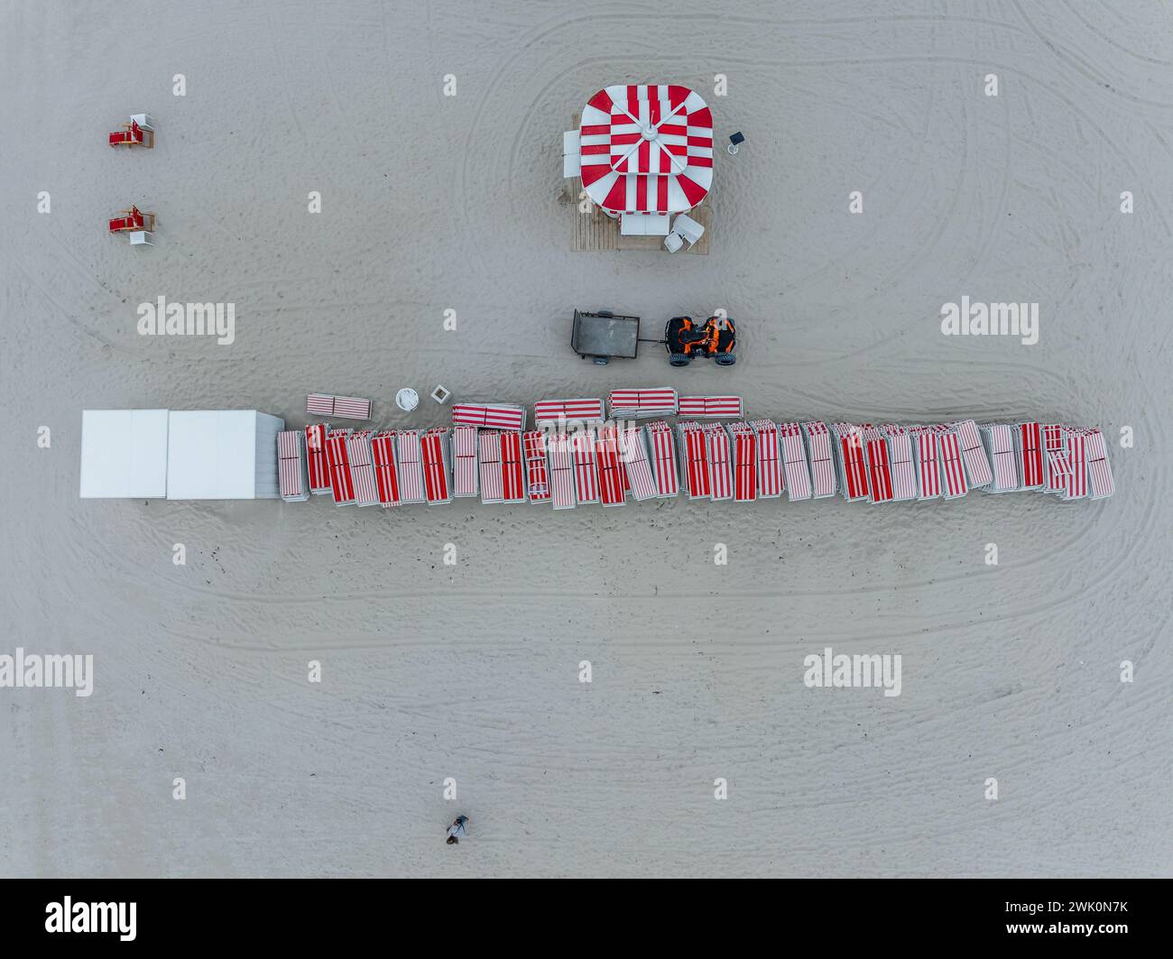 Vue aérienne de chaises de plage à rayures rouges blanches empilées sur South Beach Miami avec parasol rouge blanc Banque D'Images