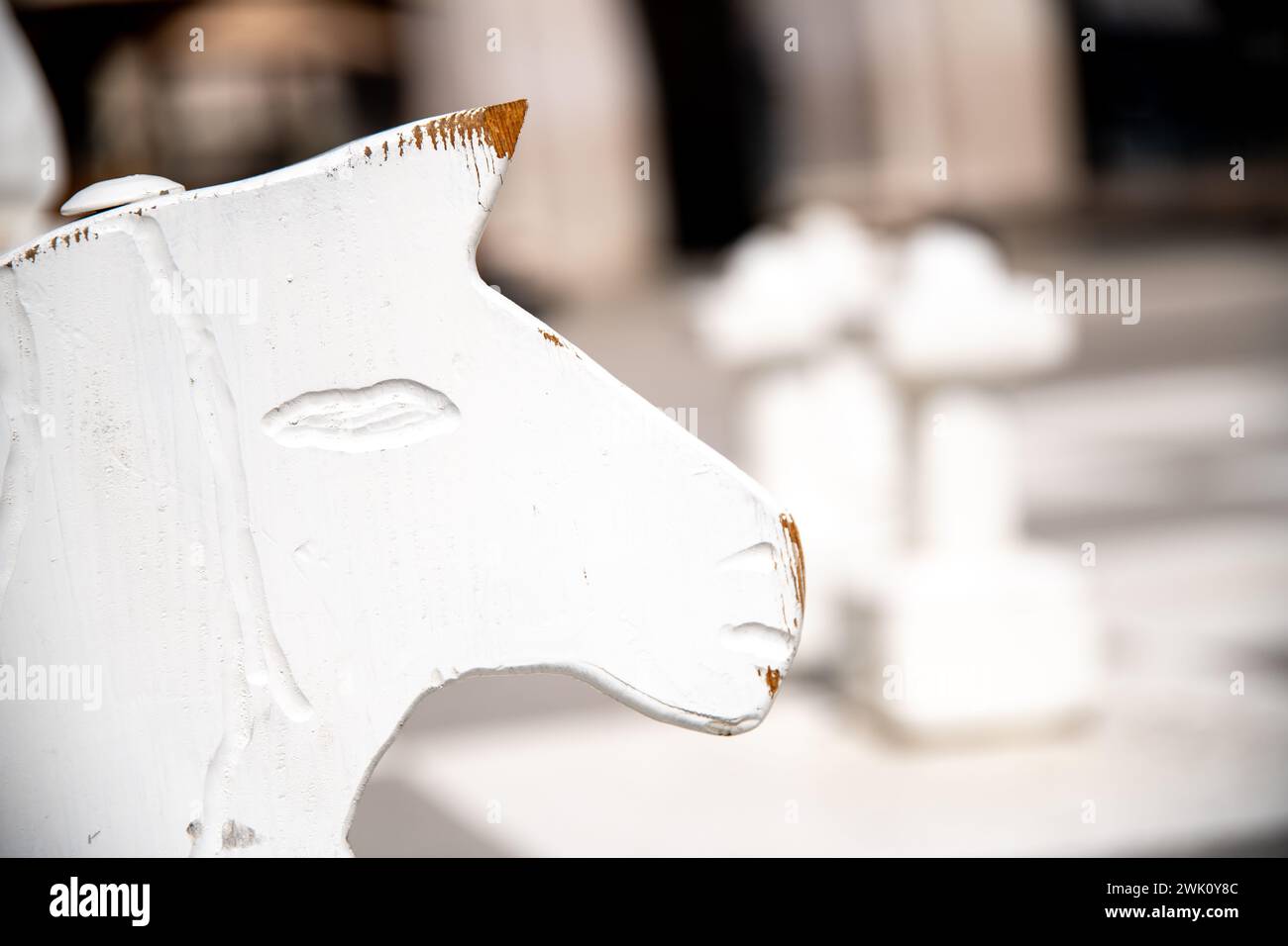 La tête usée d'un cheval blanc comme pièce de chevalier dans un grand jeu d'échecs. La peinture sur la tête et le museau est déjà rayée. Banque D'Images