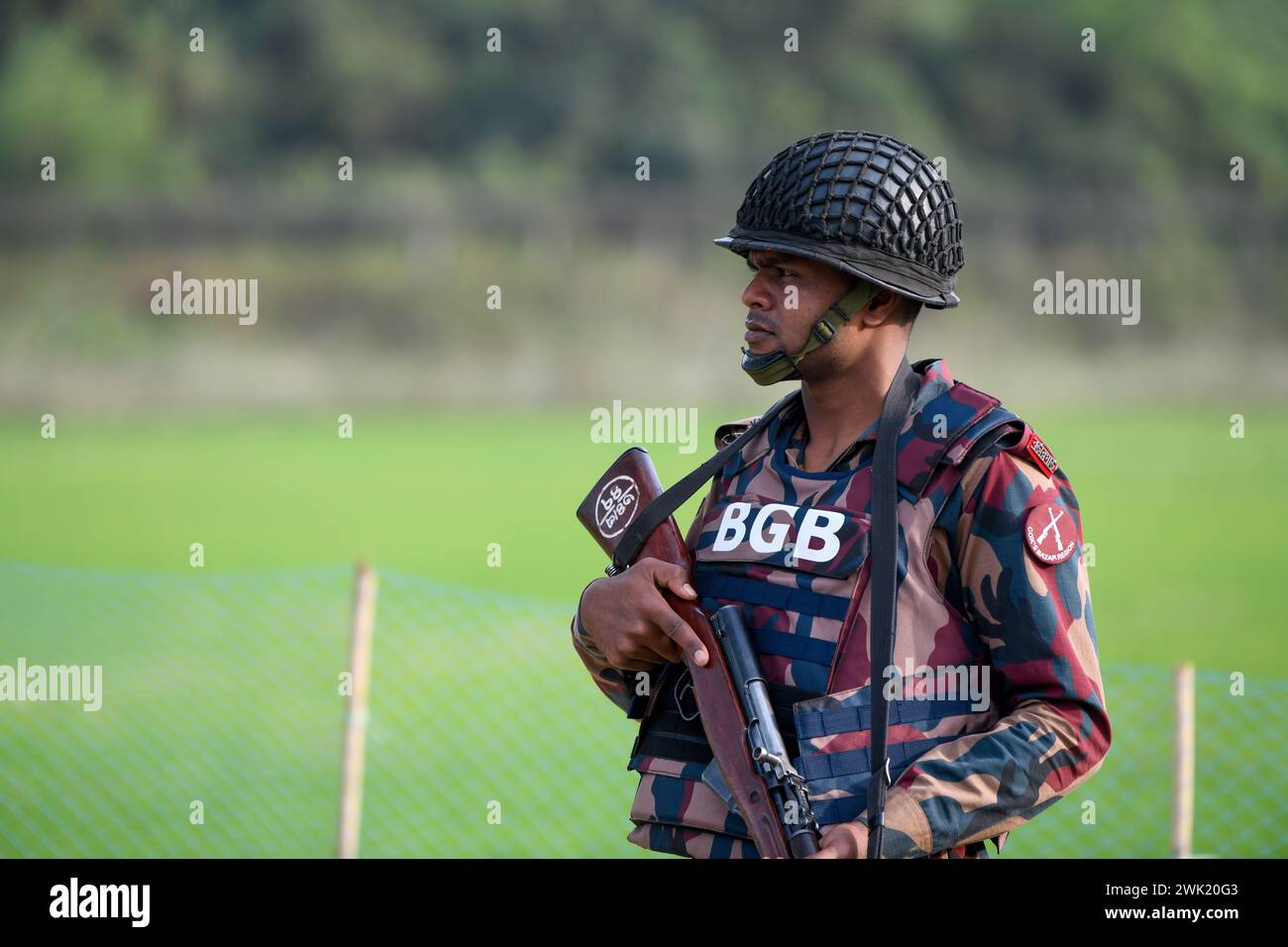 Bandarban, Bangladesh. 13 février 2024. Un membre du BGB se tient en garde dans la région de Naikhongchori, près de la frontière entre le Bangladesh et le Myanmar, dans le district de Bandarban au Bangladesh. Le conflit entre le BGP et l'armée d'Arakan, un groupe rebelle armé à l'intérieur du Myanmar, se poursuit sans relâche. Des tirs soutenus, le bruit des obus de mortier éclatant a pu être entendu à travers la zone frontalière entre le Bangladesh et le Myanmar. Des balles et des obus de mortier tirés depuis le Myanmar traversent la frontière dans les villes du Bangladesh. Crédit : SOPA images Limited/Alamy Live News Banque D'Images