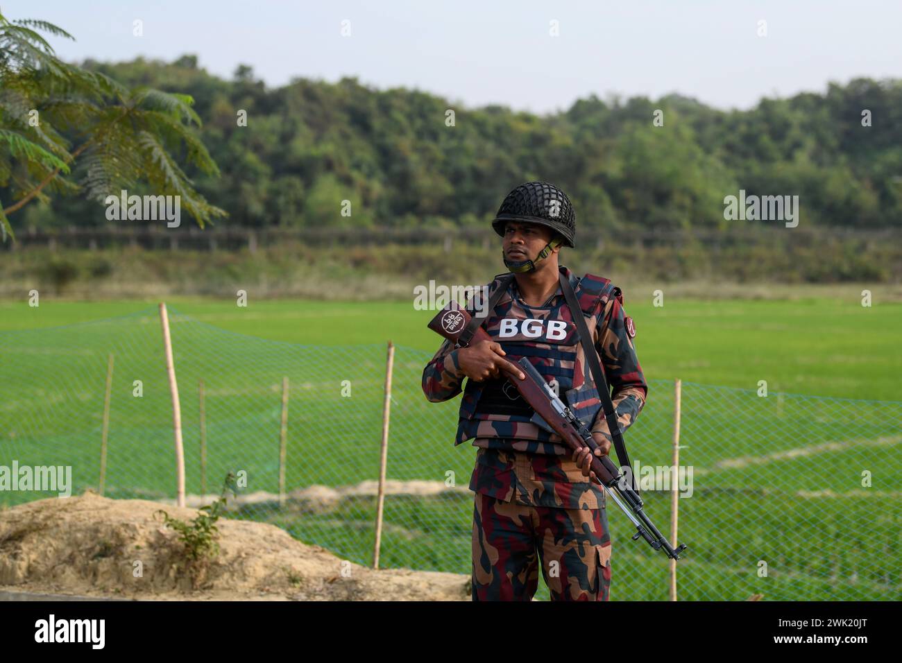 Bandarban, Bangladesh. 13 février 2024. Un membre du BGB se tient en garde dans la région de Naikhongchori, près de la frontière entre le Bangladesh et le Myanmar, dans le district de Bandarban au Bangladesh. Le conflit entre le BGP et l'armée d'Arakan, un groupe rebelle armé à l'intérieur du Myanmar, se poursuit sans relâche. Des tirs soutenus, le bruit des obus de mortier éclatant a pu être entendu à travers la zone frontalière entre le Bangladesh et le Myanmar. Des balles et des obus de mortier tirés depuis le Myanmar traversent la frontière dans les villes du Bangladesh. (Photo de Piyas Biswas/SOPA images/SIPA USA) crédit : SIPA USA/Alamy Live News Banque D'Images