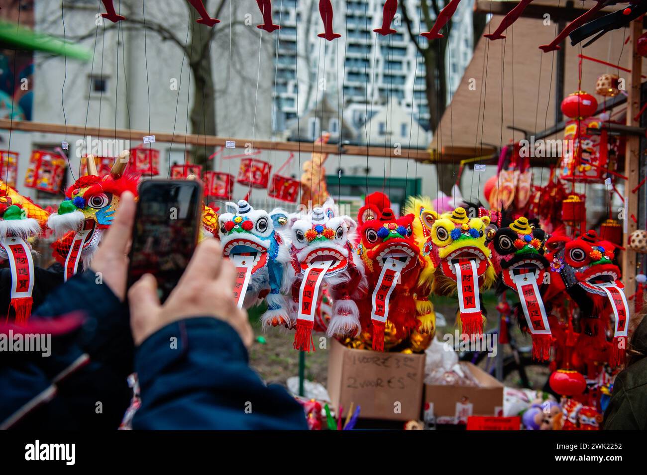 Un homme prend une photo de petits dragons dans l'un des étals du marché. Les danseurs de lion et de dragon défilent dans les rues de Rotterdam pour bénir les entrepreneurs du nouvel an. La cérémonie de danse du lion assure que les mauvais esprits sont chassés et apporte la prospérité et le bonheur pour la nouvelle année. Les communautés chinoises du monde entier ont accueilli mardi l'année du Dragon, inaugurant le nouvel an lunaire avec des prières, des fêtes familiales et des courses. C'est un festival annuel de 15 jours qui commence avec la nouvelle lune entre le 21 janvier et le 20 février dans les calendriers occidentaux. Banque D'Images