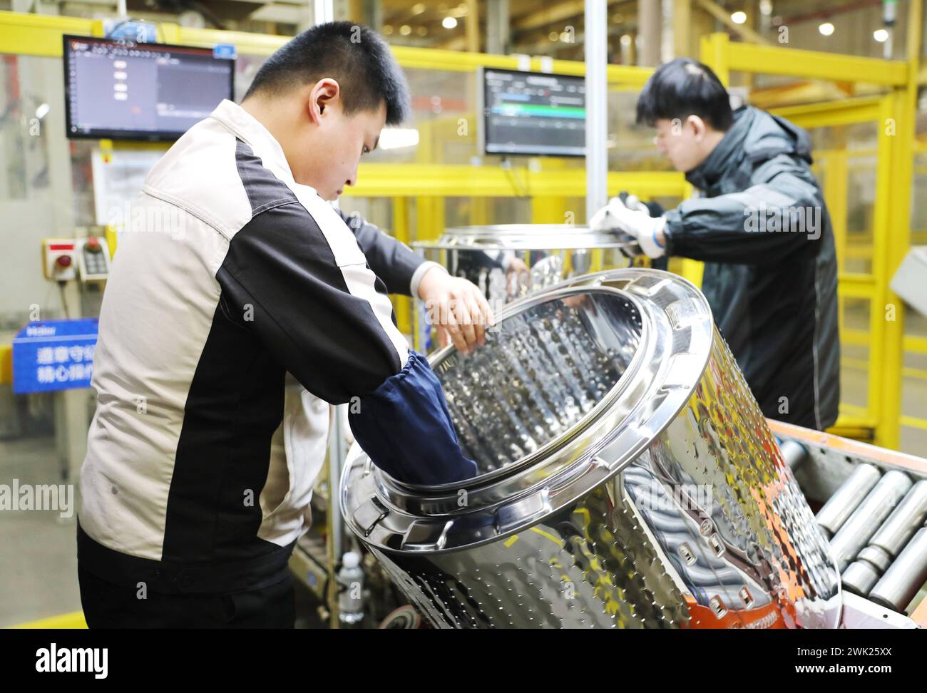 QINGDAO, CHINE - 18 FÉVRIER 2024 - des travailleurs travaillent sur une ligne de production à l'usine d'interconnexion de machines à laver Haier dans la région de Qingdao au Shandong Banque D'Images