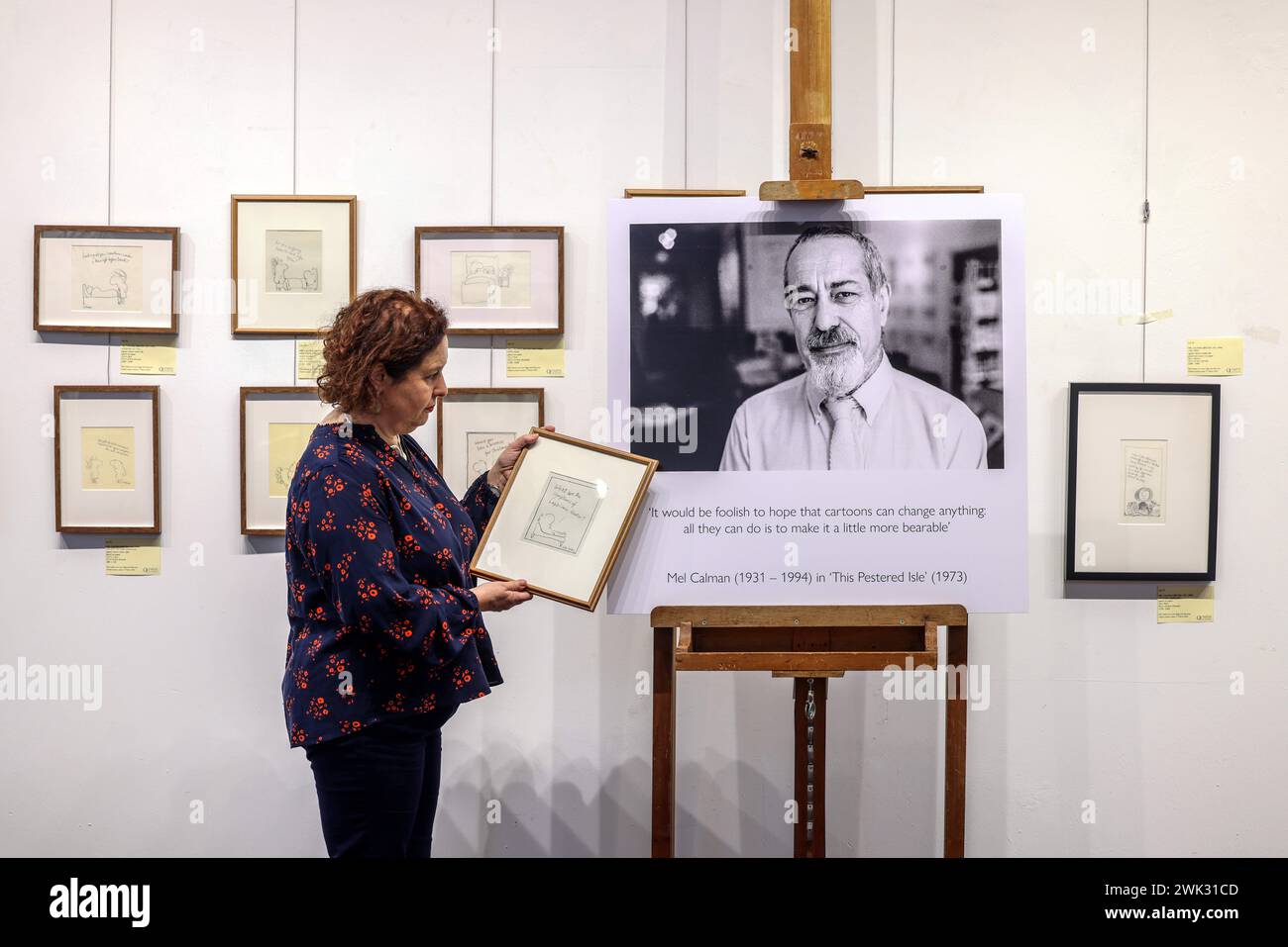 Londres, Royaume-Uni. 18 février 2024. Claire Calman, à côté d'une photo de son défunt père Mel et de certains de ses dessins animés Olympia Auctions offrent la plus grande collection d'œuvres de Mel Calman jamais vendues aux enchères. Les œuvres couvrent les thèmes de l'amour, de la rage et de la névrose. Il y a exactement 30 ans depuis la mort de Calman. Exposition dans la Galerie Olympia Auctions ouvre du lundi 19 février au vendredi 1er mars. Crédit : Paul Quezada-Neiman/Alamy Live News Banque D'Images