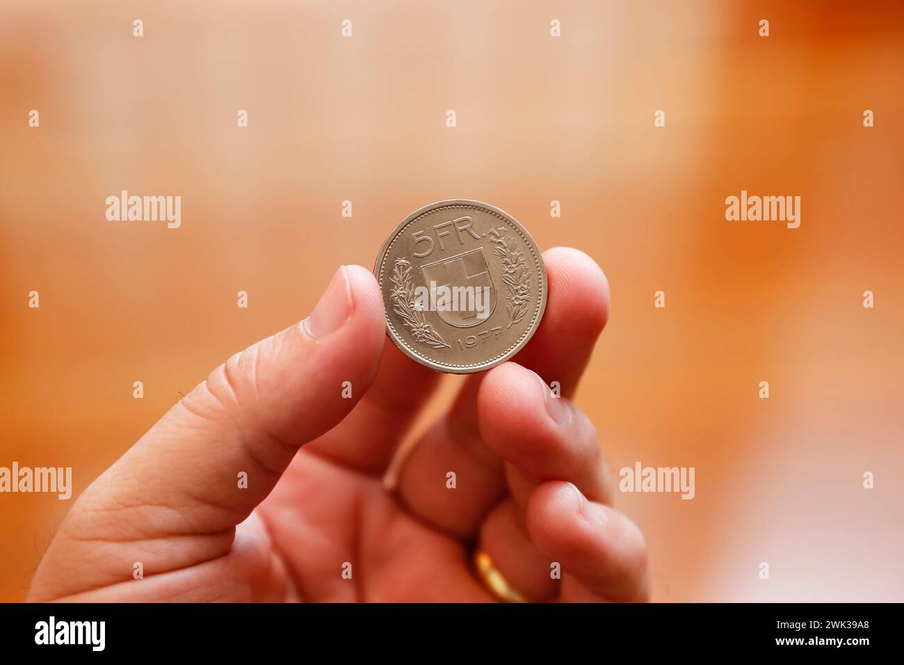 pièce suisse de cinq francs entre les doigts - pièce en franc suisse Banque D'Images