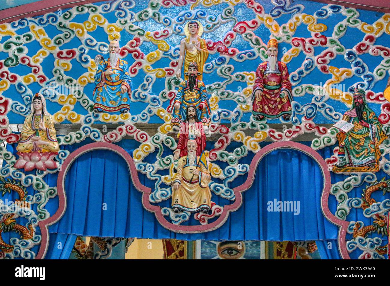 Sa Đéc, Vietnam. 18 février 2024 : Temple Cao Đài où sont pratiquées les cérémonies et les prières des fidèles du Caodaïsme. Cette religion syncrétique monothéiste vietnamienne, revendiquant 5 millions de croyants dans le monde entier, a célébré la Grande cérémonie de l’être suprême en l’année du Dragon 2024, comme chaque année le 8/9ème jour du premier mois lunaire. De gauche à droite : Bodhisattva, Laozi (Lao Tzu), Bouddha, Li Bai, Jésus Christ, Jiang Ziya, Confucius, Guan Yu. Cette foi rassemblant toutes les religions célébrera son 100e anniversaire officiel en 2026. Crédit : Kevin Izorce/Alamy Live News Banque D'Images