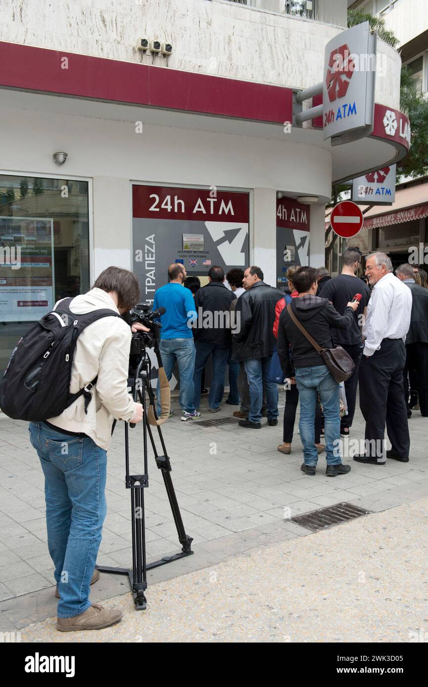 Les gens à Nicosie tirant de l'argent à un distributeur automatique de la Banque populaire. Les médias étrangers les filment. Banque D'Images