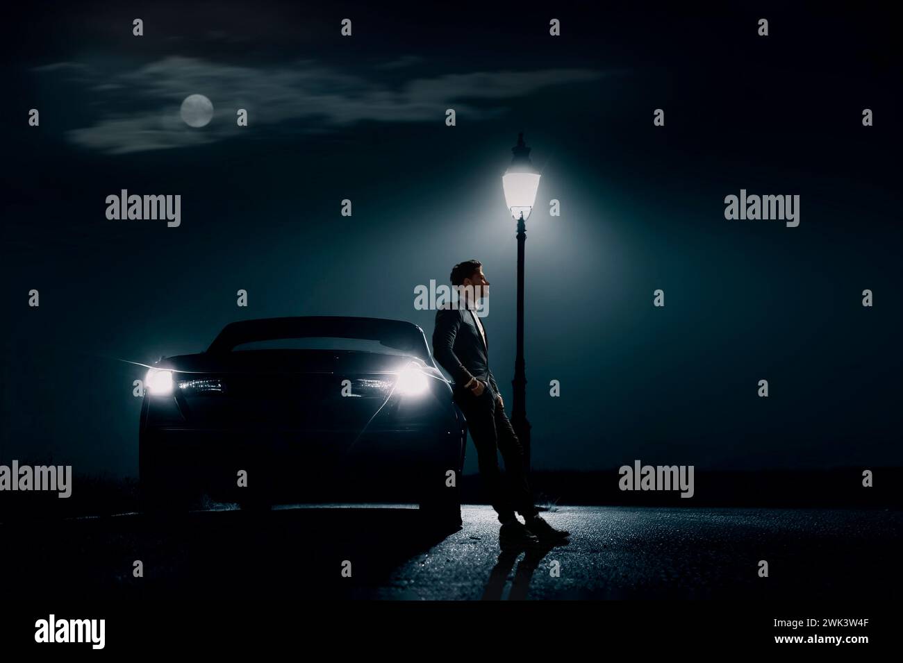 Homme appuyé contre la voiture avec lampadaire la nuit, USA Banque D'Images