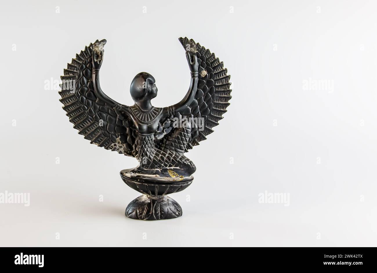 Gros plan d'une figurine miniature de l'ancien Dieu égyptien ailé Isis. Banque D'Images