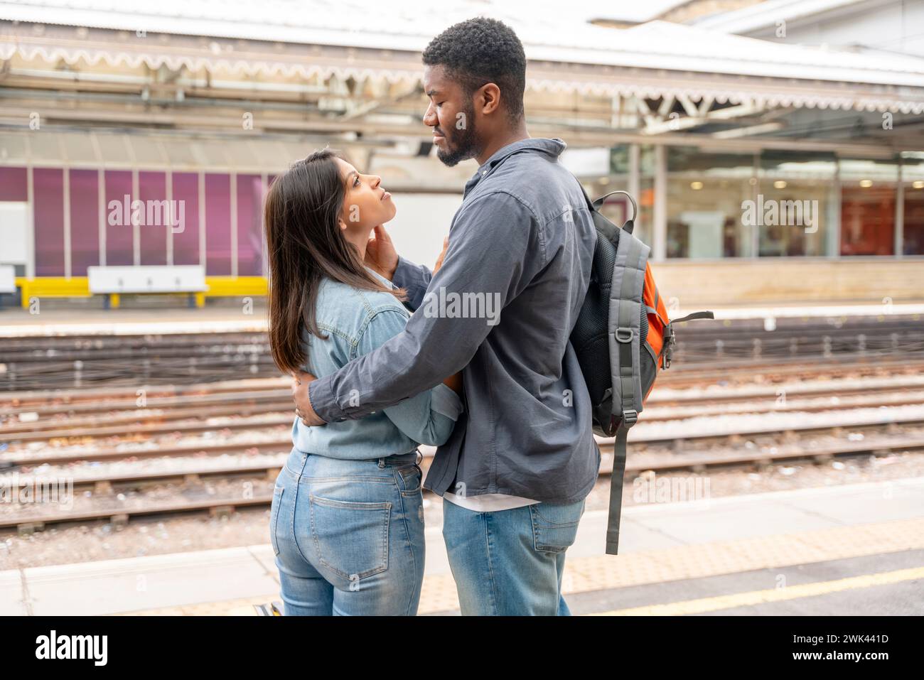 un jeune beau couple embrasse sur la réunion de plate-forme, disant au revoir le conjoint, ami. Concept de style de vie de voyage Banque D'Images