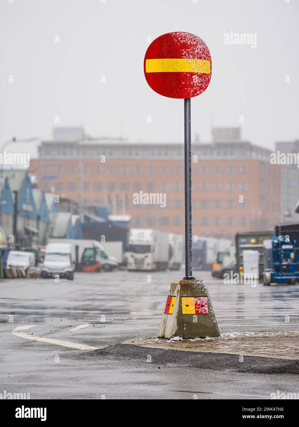 L'image montre un panneau d'interdiction d'entrée rouge et jaune vif sur une rue urbaine humide avec des gouttes de pluie ou de la brume visibles. L'atmosphère brumeuse crée un flou aro Banque D'Images