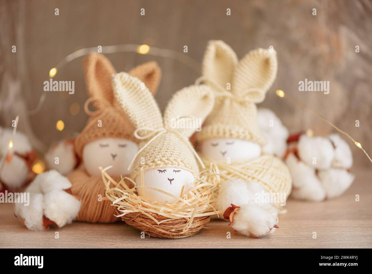 Oeufs de Pâques dans des chapeaux tricotés au crochet avec des oreilles de lapin dans le nid. Concept de célébration de Pâques Banque D'Images
