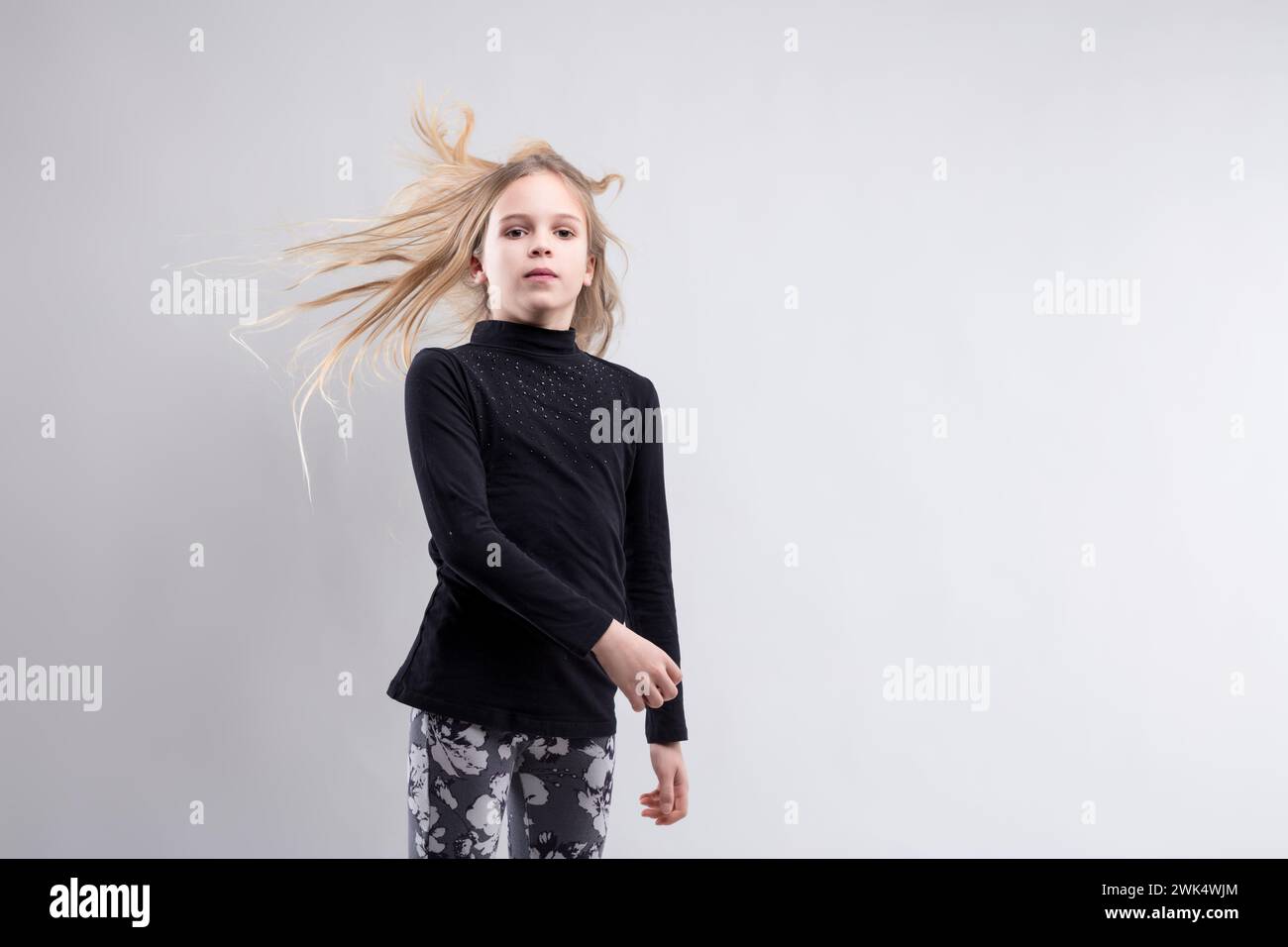 Les cheveux blonds s'enroulent autour de la silhouette d'une jeune fille, symbolisant la liberté et la spontanéité Banque D'Images