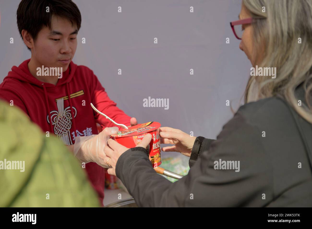 Rome, Italie. 18 février 2024. Un homme vend un paquet de nouilles lors des célébrations du nouvel an chinois à Rome. (Crédit image : © Marcello Valeri/ZUMA Press Wire) USAGE ÉDITORIAL SEULEMENT! Non destiné à UN USAGE commercial ! Banque D'Images