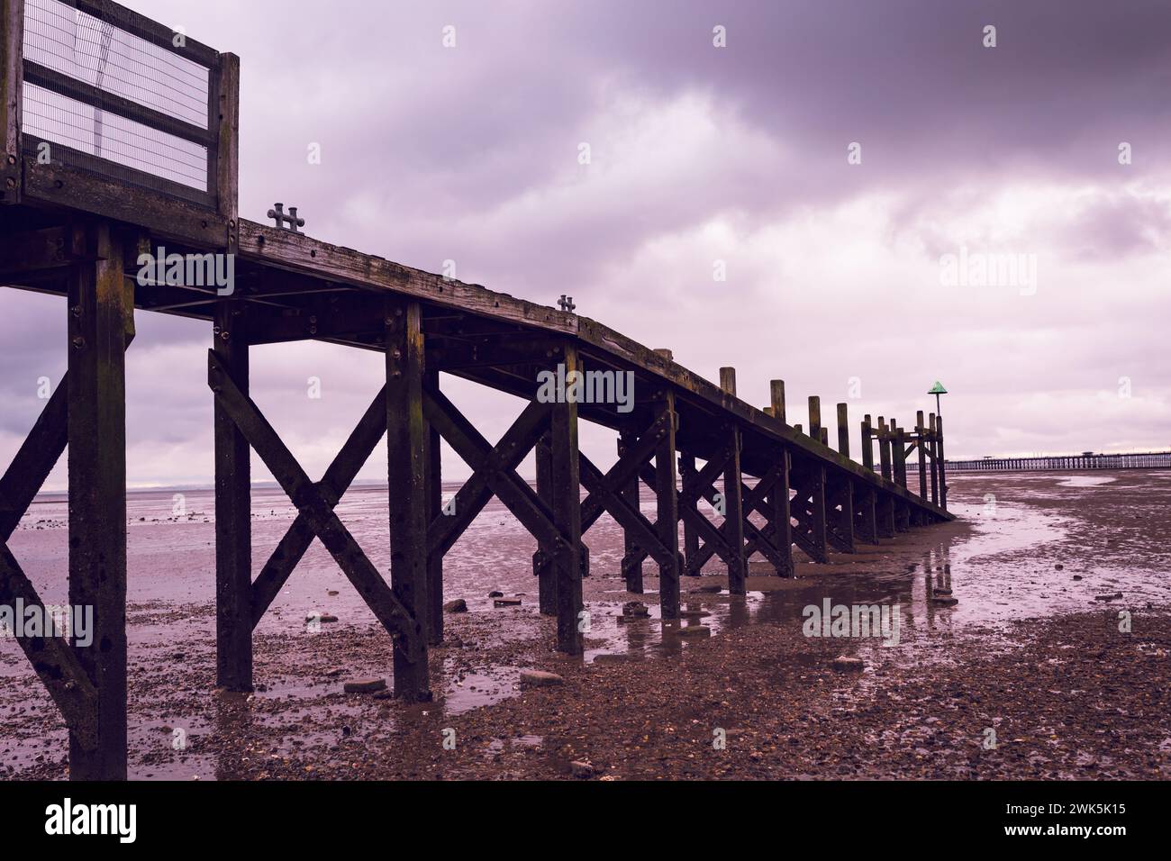 Paysages de voyage cinématographique côtier vue d'une cructure en bois à marée basse le long de l'estuaire de la Tamise. Violet, Bronze, couleurs cuivre. Banque D'Images