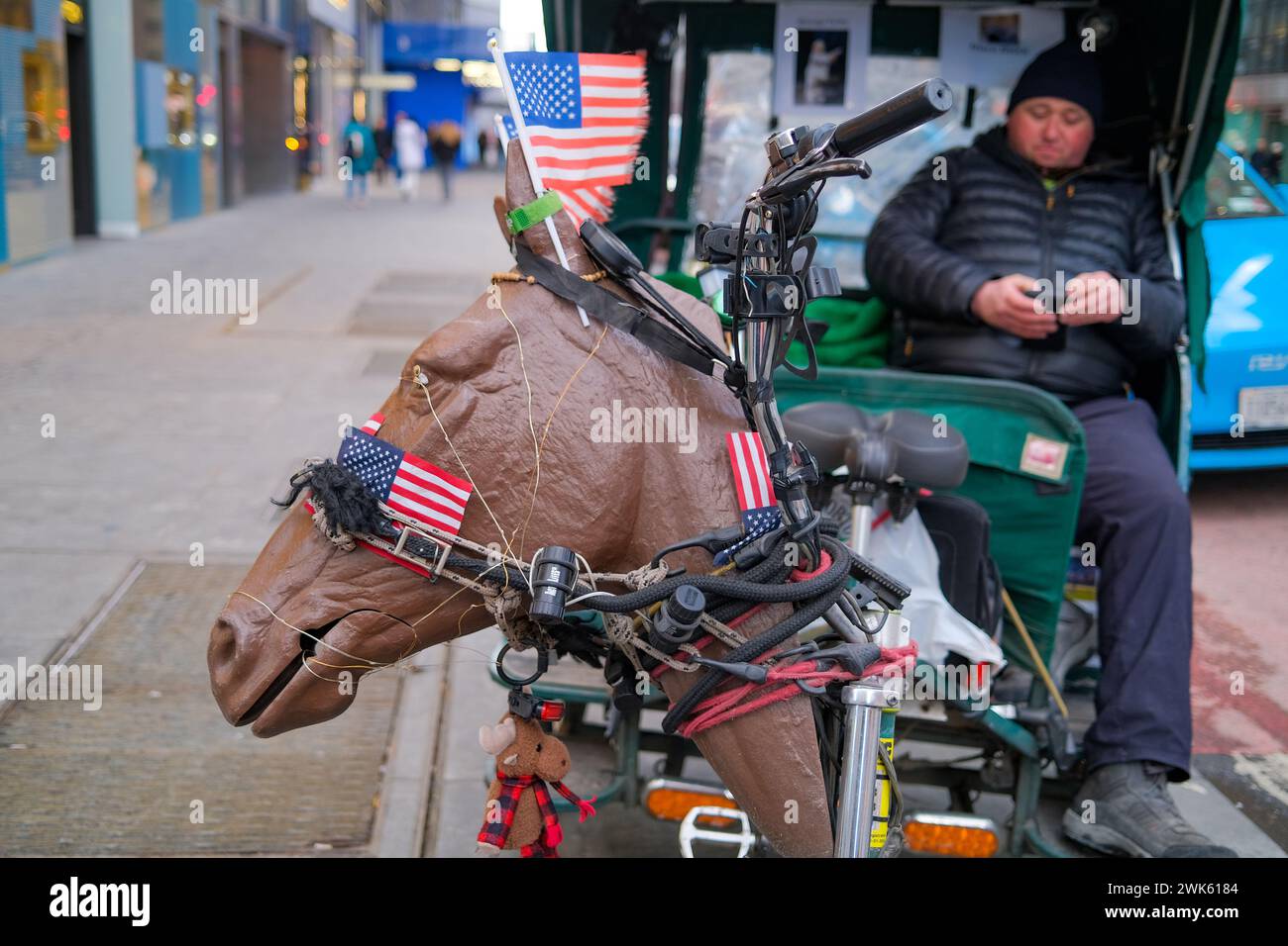 New York, New York, États-Unis. 17 février 2024. Puissance de cheval mais pédicab à propulsion humaine près de Central Park. Comme alternative aux calèches vivantes, ces véhicules à propulsion humaine emmènent généralement des touristes pour des promenades autour du célèbre parc. Ce chauffeur et son taxi ressemblaient plus à des chevaux que la plupart des autres. (Crédit image : © Milo Hess/ZUMA Press Wire) USAGE ÉDITORIAL SEULEMENT! Non destiné à UN USAGE commercial ! Banque D'Images