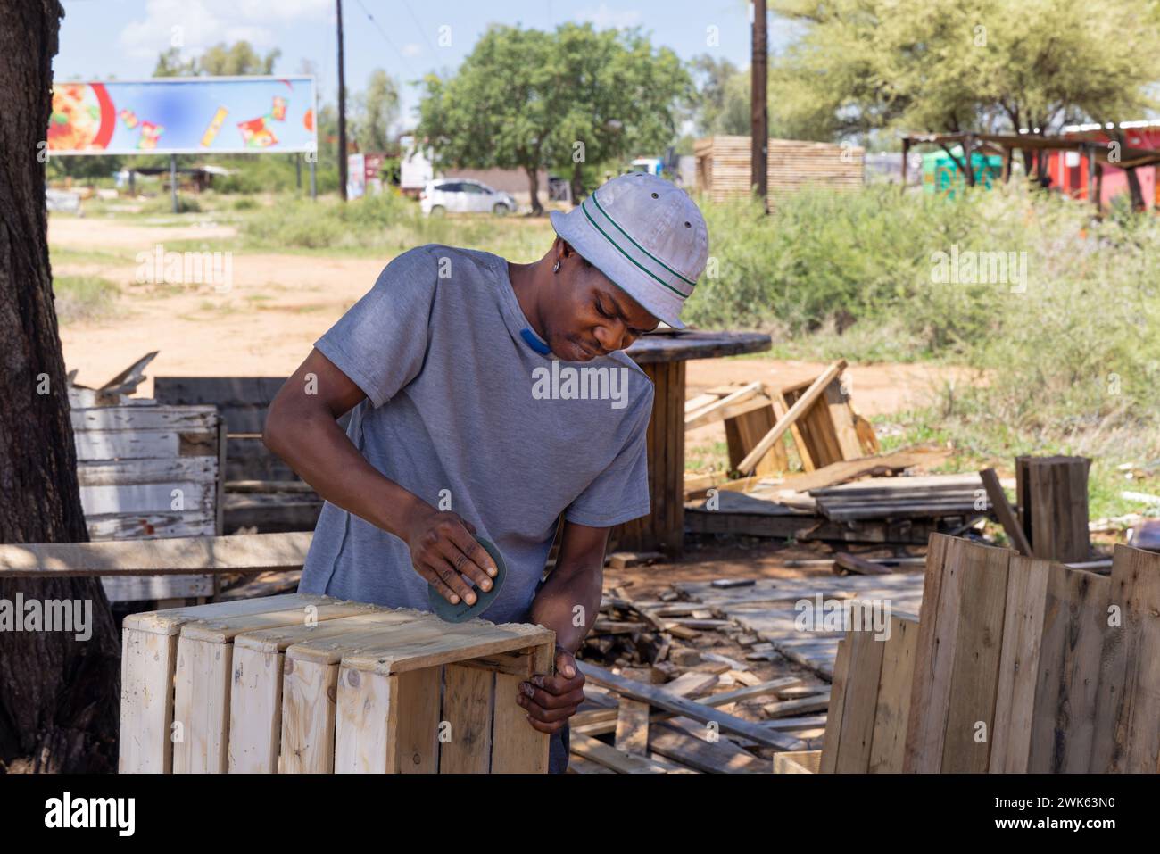 charpentier afro-américain faisant une maison wendy, hangar en bois à l'extérieur, gros plan, il meule les planches et les assemble en panneaux Banque D'Images