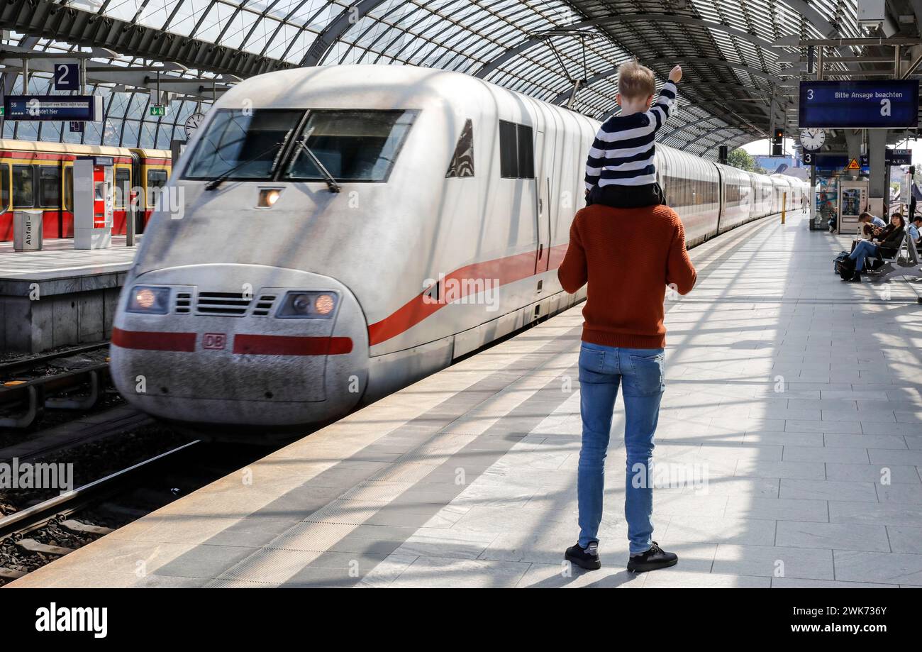 Un père porte son fils sur son épaule tandis qu'un train ICE DE la Deutsche Bahn arrive à la gare de Berlin Spandau, 27/05/2020 Banque D'Images