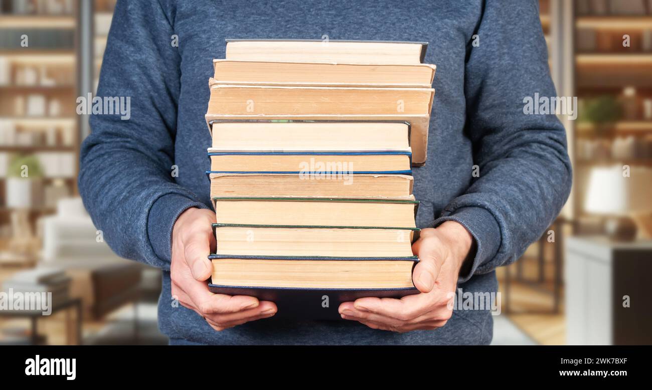 Un homme avec une pile de livres dans les mains Banque D'Images
