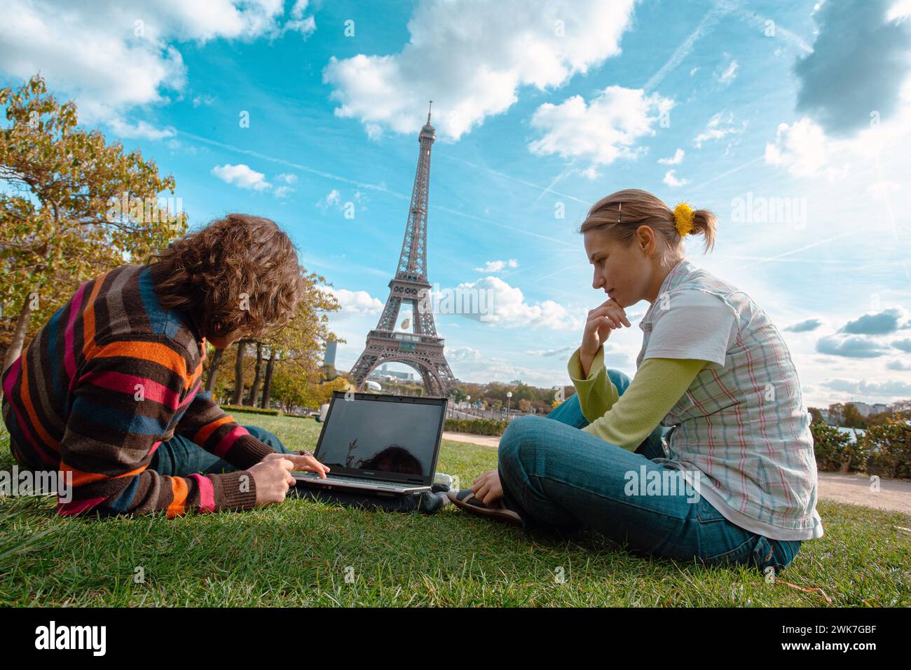 FRANCE / Ile de France / Paris / les jeunes sur la pelouse du jardin du Trocadéro avec la Tour Eiffel au loin à l'aide d'un ordinateur portable. Banque D'Images