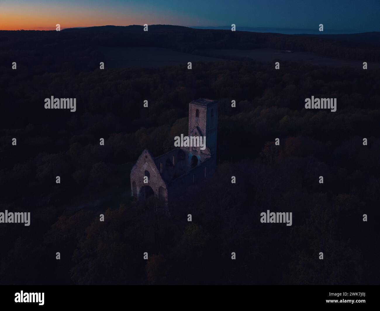 Vue aérienne des anciennes ruines du château historique au milieu de la forêt. Drone vue du paysage naturel avec forteresse cassée pendant le coucher du soleil. Banque D'Images