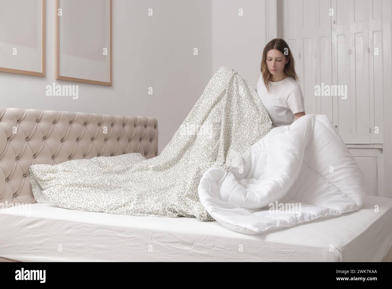 Femme changeant le linge de lit à la maison dans sa chambre à coucher, style de vie domestique confortable, ménage de femme au foyer, rangement de la chambre, concept de ménage. Banque D'Images