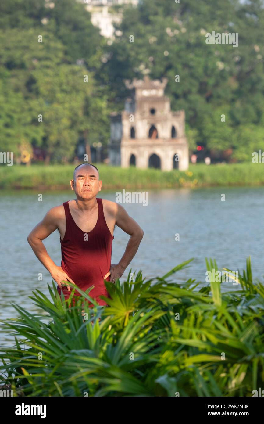 Homme faisant des exercices tôt le matin autour du lac Hoan Kiem à Hanoi, Vietnam Banque D'Images