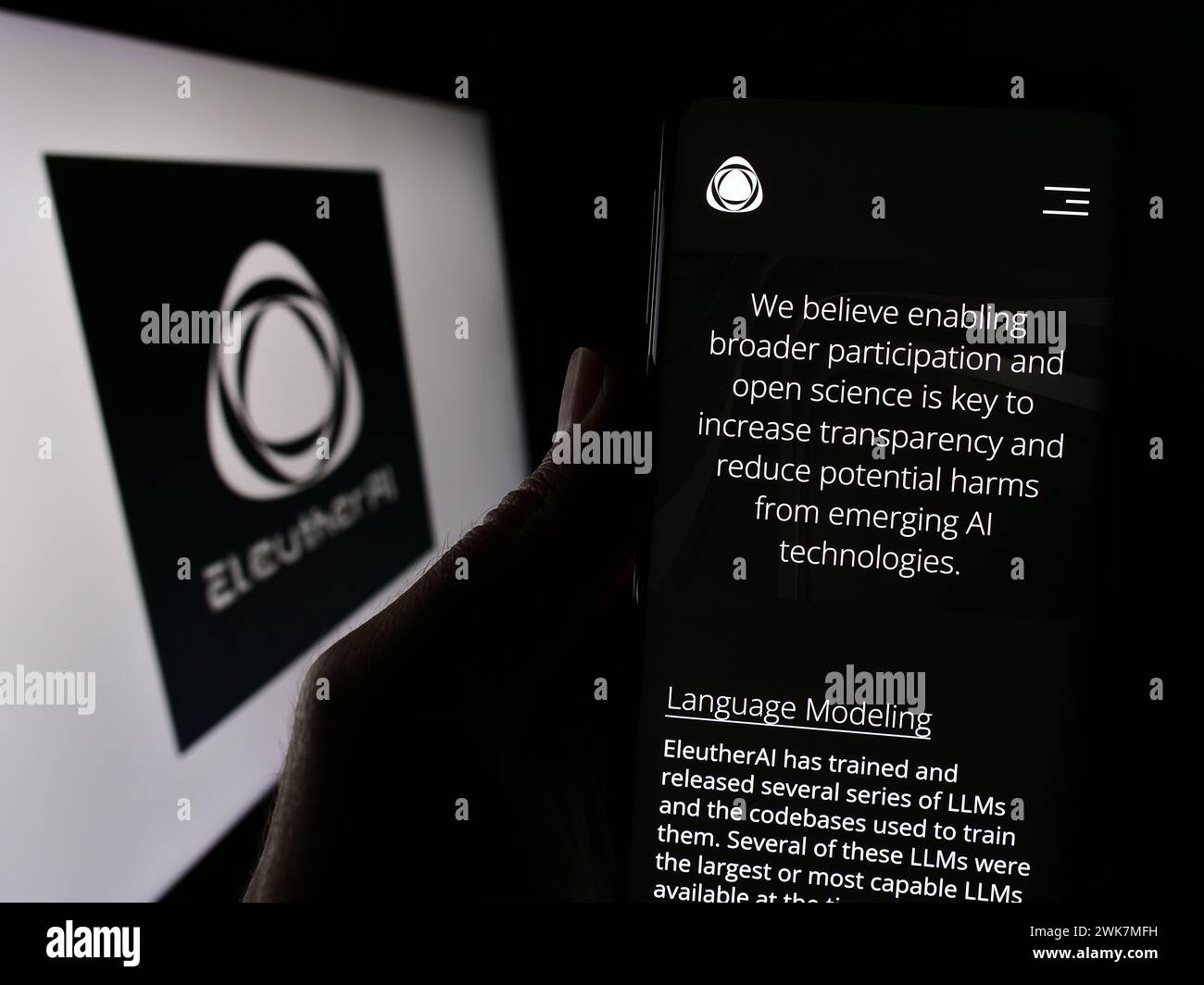 Personne tenant le téléphone portable avec la page Web du groupe de recherche en intelligence artificielle EleutherAI devant le logo. Concentrez-vous sur le centre de l'écran du téléphone. Banque D'Images