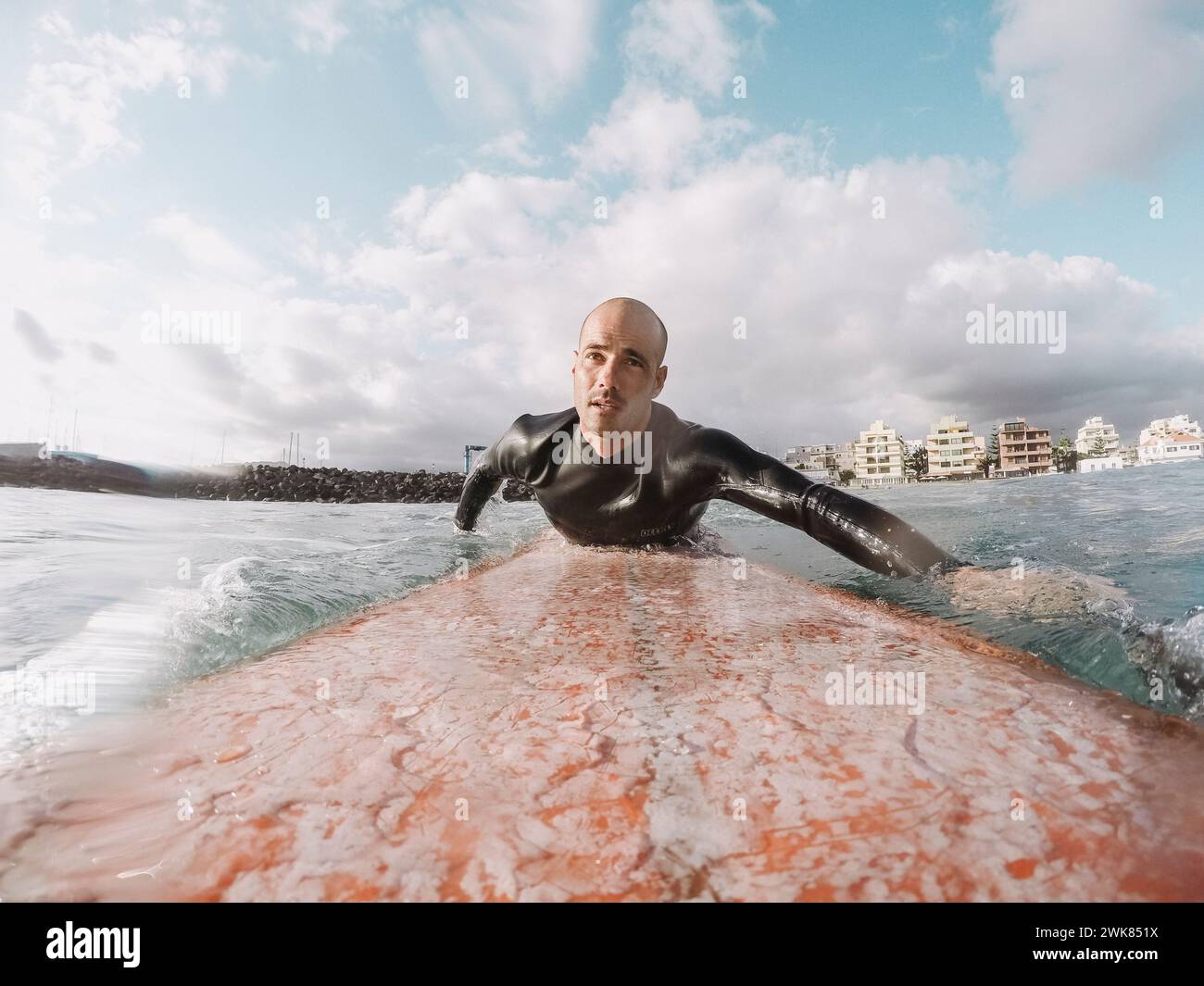 Surfeur pagayant sur planche de surf, Tenerife, Îles Canaries, Espagne Banque D'Images