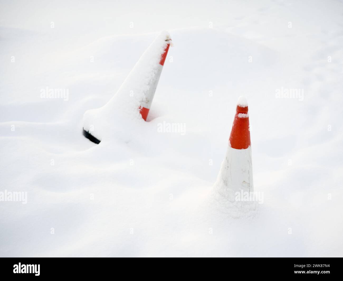 Cônes rouges de sécurité routière recouverts de neige Banque D'Images