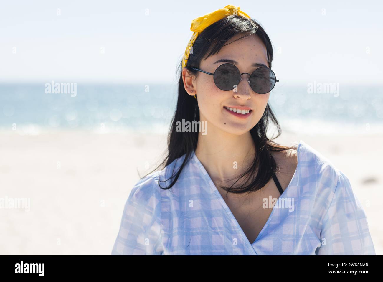 Jeune femme biraciale profite d'une journée ensoleillée à la plage Banque D'Images